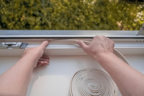 Man installing window stripping for insulating windows in Perth.