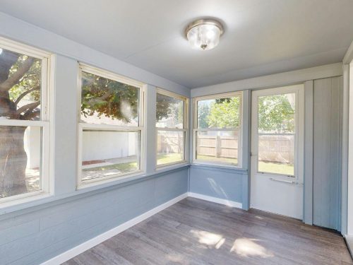 Corner of an Australian home with multiple white double-hung windows.
