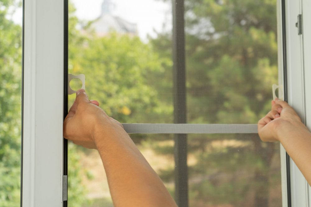 Someone reaches to hold a fly screen