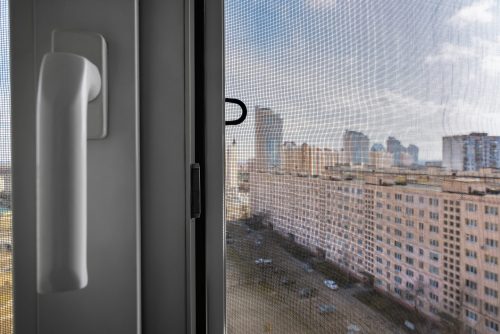 A city seen through a fly screen door