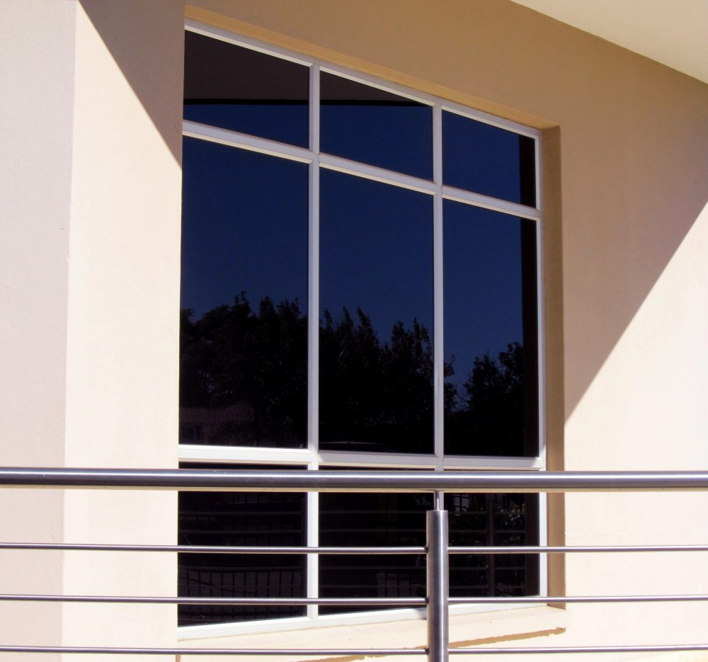 A frameless window in front of a balcony rail