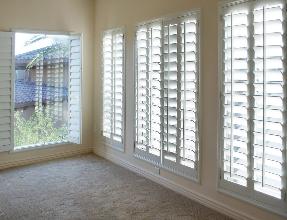 Empty room with shutters used as a window treatment.