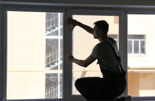 Worker installing windows in frame